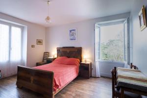 a bedroom with a bed and a large window at Le haut Picot in Bussac