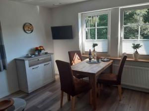 a dining room with a wooden table and chairs at Ferienwohnung Zur Basemicke in Schmallenberg +27 photos