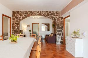 a living room with a table and a stone wall at Disfruta De La Costa Brava in Lloret de Mar +27 photos