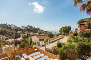 a patio with lounge chairs and the ocean in the background at Disfruta De La Costa Brava in Lloret de Mar