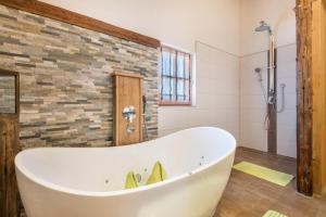 a bath tub in a bathroom with a brick wall at Ferienwohnung Stub´n in Freyung