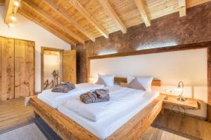 a large white bed in a room with wooden walls at Ferienwohnung Stub´n in Freyung