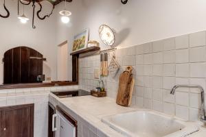 a kitchen with a sink and a clock on the wall at Tenuta Acquabona - intero casale in Gambassi Terme +32 photos