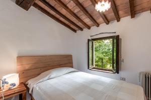 a bedroom with a bed and a window at Tenuta Acquabona - intero casale in Gambassi Terme
