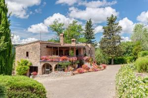 a house with flowers in front of it at Tenuta Acquabona - intero casale in Gambassi Terme
