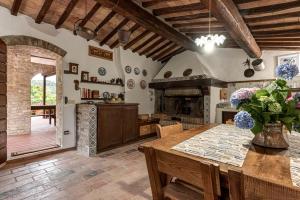 a kitchen with a wooden table and a fireplace at Tenuta Acquabona - intero casale in Gambassi Terme