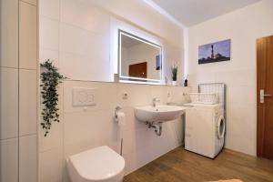 a white bathroom with a sink and a toilet at Ferienwohnung Bunsoh in Bunsoh +14 photos
