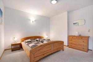 a bedroom with a wooden bed and a wooden dresser at Ferienwohnung Bunsoh in Bunsoh