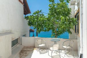 a table and chairs on a balcony with a view of the ocean at Wavedance Accommodation in Salamina