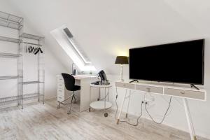 a living room with a flat screen tv on a desk at Appartement tout confort in Willstätt