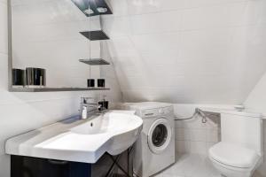 a white bathroom with a washing machine and a sink at Appartement tout confort in Willstätt +15 photos