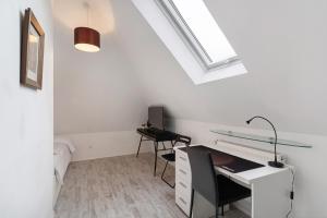 an attic office with a desk and a window at Appartement tout confort in Willstätt