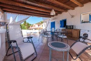 a patio with chairs and a table and a kitchen at Jerà Suite Vista Mare in Lipari