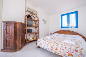 a bedroom with a bed and a wooden cabinet at Jerà Suite Vista Mare in Lipari