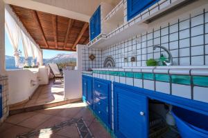 a kitchen with blue and white tiles and a sink at Jerà Suite Vista Mare in Lipari +16 photos