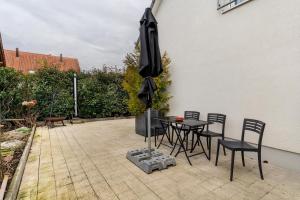 a patio with a table and chairs and an umbrella at Appartement tout confort in Willstätt