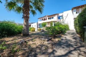a house with a palm tree next to a sidewalk at Jerà Suite Vista Mare in Lipari