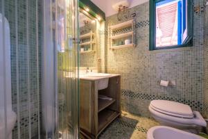 a bathroom with a toilet and a sink and a shower at Jerà Suite Vista Mare in Lipari