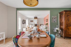 a dining room with a wooden table and chairs at Chambre d'hôtes - La Gâtine in Rochecorbon
