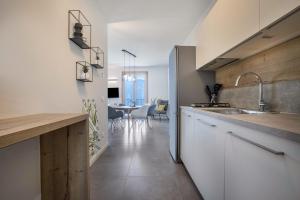 a kitchen with white cabinets and a dining room at Casa Panoramica in Tignale