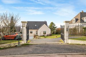 a gate to a house with a red truck behind it at Chambre d'hôtes - La Gâtine in Rochecorbon