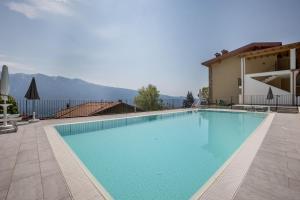 a large swimming pool with blue water in front of a building at Casa Panoramica in Tignale