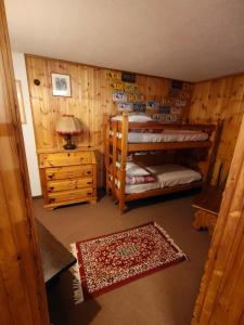 a bedroom with two bunk beds and a night stand at Casa Rita - Pila in Gressan