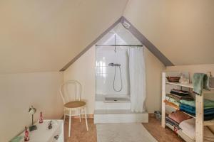 a attic bathroom with a shower and a chair at Chambre d'hôtes - La Gâtine in Rochecorbon