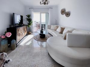 a white living room with a white couch and a tv at Rd02 La Casa Hermosa in Torrox