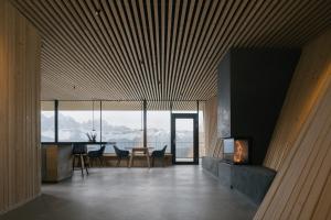 a living room with a fireplace and a table with chairs at anders mountain suites 4 in Brixen