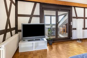 a living room with a flat screen tv on a white cabinet at Ferienwohnung Cherine in Gailingen