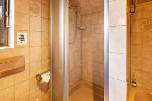 a bathroom with a shower and a tub and a sink at Ferienwohnung Cherine in Gailingen +18 photos