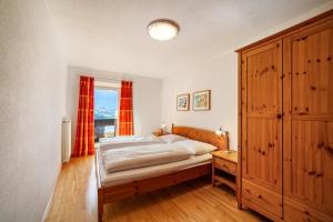 a bedroom with a bed and a wooden cabinet at Gasserhof Ferienwohnung Gravenstein in Caines +32 photos