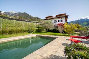 a swimming pool in a yard with a house at Gasserhof Ferienwohnung Gravenstein in Caines