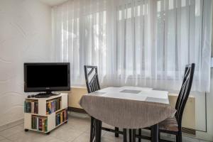 a dining room with a table and a television at Fewo Eg Rechts - Hunde erlaubt in Oberteuringen