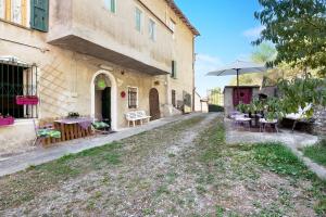 a building with tables and an umbrella next to a road at Orizzonte Calmo in Borghetto Di Borbera