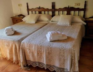 two beds in a bedroom with towels on them at Apartamento Rural Jana in Alles