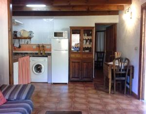 a kitchen with a white refrigerator and a table at Apartamento Rural Jana in Alles