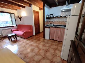 a living room with a red chair and a kitchen at Apartamento Rural Jana in Alles