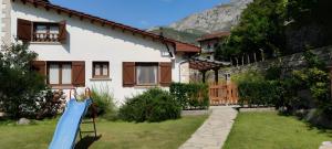 a house with a blue slide in the yard at Apartamento Rural Jana in Alles