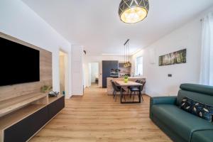 a living room with a couch and a tv and a table at Jj City Apartment in Lagundo