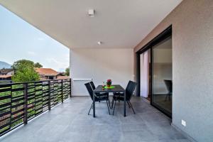 a patio with a table and chairs on a balcony at Jj City Apartment in Lagundo
