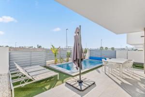 a patio with a table and an umbrella and a pool at El Sueño in Orihuela
