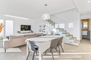 a dining room with a table and chairs and a staircase at El Sueño in Orihuela