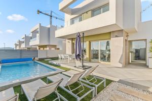 a villa with a swimming pool and chairs at El Sueño in Orihuela