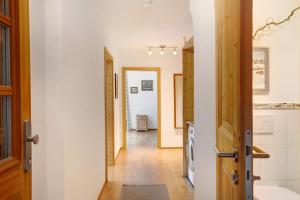 a kitchen with white walls and a wooden door at Ferienwohnung Zugspitzblick in Grainau +20 photos