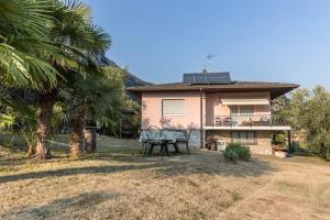 a house with a table and a palm tree at Casa Zanoni in Arco