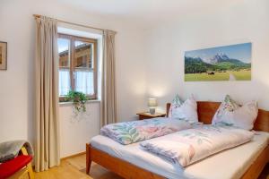 a bedroom with a bed with a window at Ferienwohnung Zugspitzblick in Grainau