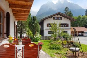 a patio with chairs and a table and a house at Ferienwohnung Zugspitzblick in Grainau