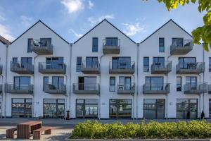 a large white building with windows and balconies at Reeders Topp by Seeblick Ferien in Olpenitz
